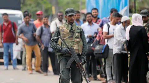 Reuters Sri Lankan army personnel stand guard at a checkpoint as they search people and their bags at a check point in Kattankudy near Batticaloa, Sri Lanka, 28 April