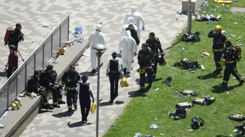 Getty Images Police, firefighters and forensic science teams outside Grenfell Tower