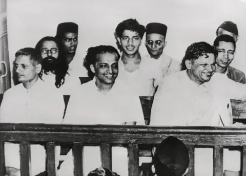 Alamy Front row, L-R: Nathuram Godse; Narayan Apte, Vishnu Karkare. 2nd Row, L-R: Digambar Ramchandra Badge (obscured); Shankar Kistaiya; Gopal Godse. 3rd Row: no ID; Vinayak Savarkar; S.D.Parchure. May 1948