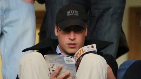 Getty Images Prince William reading a Blackpool FC programme