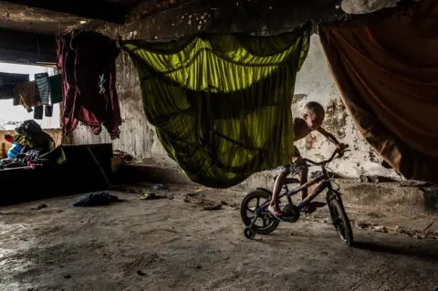 Tariq Zaidi A resident rides his bike in the occupied IBGE building, 'Favela' Mangueira community, Rio de Janeiro, Brazil.