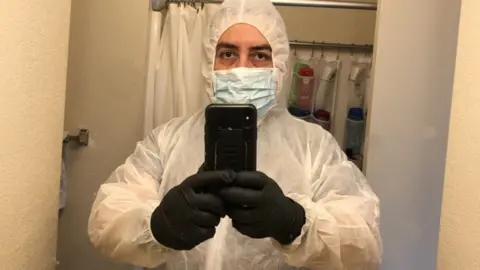 José Zaragoza José Zaragoza in his cleaning gear, including a full body coverall, gloves and a mask