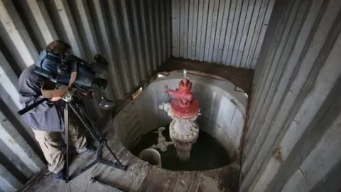 Peter Macdiarmid/Getty Images A cameraman films the well