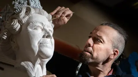 Duncan Lomax, Ravage Productions Richard Bossons designed the statue of the late Queen