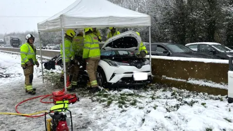 Glos Fire Firefighters help occupants of a car caught up in a crash on the M5