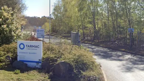 Google Entrance to quarry with long dust road and Tarmac sign