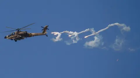 EPA An Israeli Apache helicopter releases flares during a raid in the West Bank city of Jenin (19 June 2023)