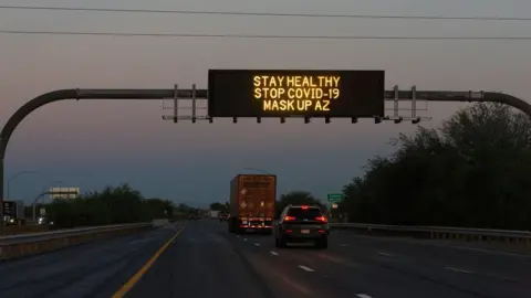 Reuters A freeway sign reads 'stay healthy, stop Covid-19, mask up AZ'