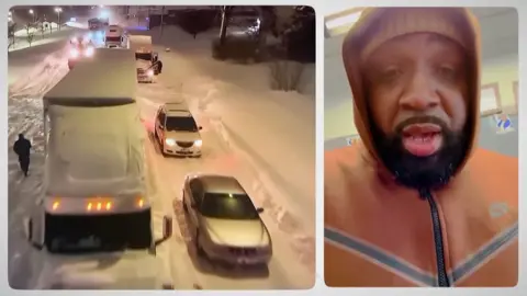 cars stranded in snow and man in hooded jacket