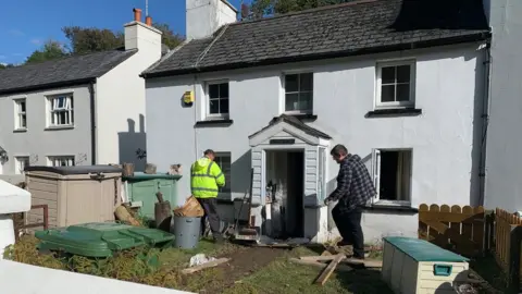 Men clearing our damaged items form a house