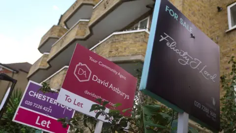 PA Media A black of flats with for sale and to let signs outside (file photo)