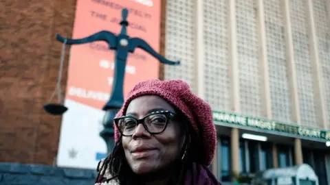 AFP Tsitsi Dangarembga staring on in a red beret