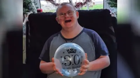 Family handout Sam holding 30th birthday