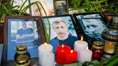 Reuters Candles are placed next to the portraits of Vitaly Shishov in Kyiv, Ukraine