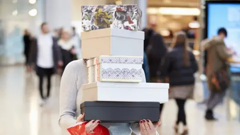 Getty Images Carrying a stack of boxes and bags