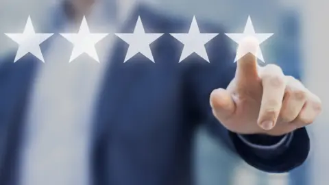 Getty Images A man selecting five stars on a screen