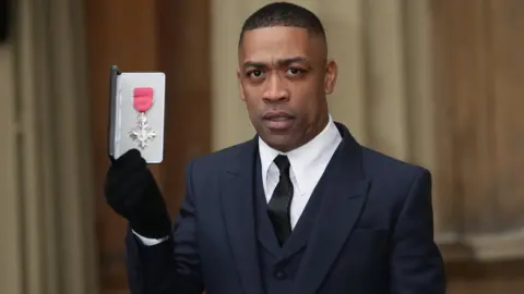 PA Media Wiley with his MBE in 2018