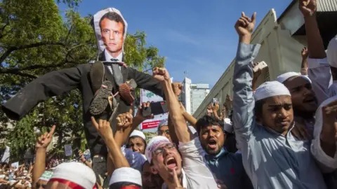 EPA Protesters hold an effigy of French President Macron in Dhaka