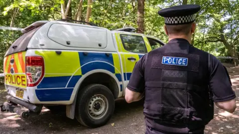 Essex Police A police vehicle and police officer in Hockley Woods