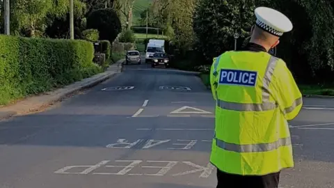 ASPolice A police officer standing in the road with a speed camera