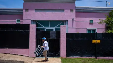 Getty Images An anti-abortion protestor moves a sign from outside at the Jackson Womens Health Organization also known as the The Pink House in Jackson, MS on June 7, 2022