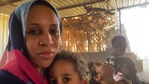 Woman sits with her children