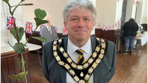 Mayor of Trowbridge, Graham Hill smiling with bunting behind him