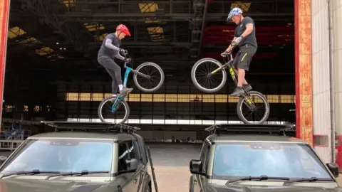 BBC BMX brothers Ashley and Danny Butler jumping over land rover robes for Cirque Bijoux