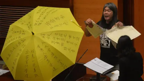 AFP Leung Kwok-hung - known as "Long Hair" - of the League of Social Democrats shouts slogans and rips up the "831 ruling" before taking the Legislative Council Oath