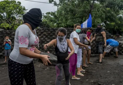 Javier Bauluz Women and girls build a barricade in Managua after an attack, some hours previously, by police and paramilitaries