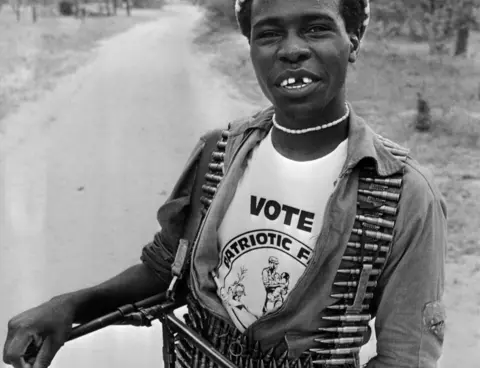 AFP A fighter who supports the Patriotic Front carrying bullets and a machine gun, smiles during the general elections, March 04, 1980 in Lupane camp