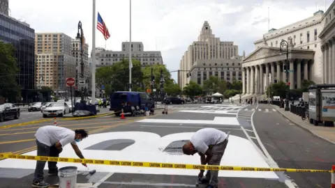 EPA Two men work on the recently painted giant letters spelling out "Black Lives Matter" as seen in front of the Federal Court in Lower Manhattan in New York, USA, 01 July 2020