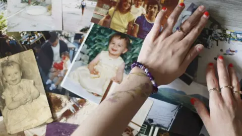 Margaret Mitchell Outstretched hands over a selection of old photographs