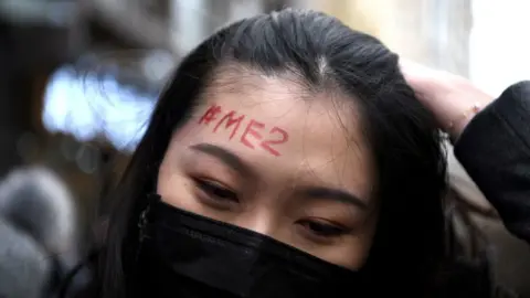 Getty Images A supporter of Zhou Xiaoxuan, a feminist figure who rose to prominence during Chinas #MeToo movement, has a #MeToo penned on her forehead