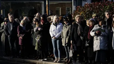 PA Media Members of the public line the street near to Iveagh Hall, in Leigh-on-Sea, the constituency office of murdered MP Sir David Amess, as they wait to pay their respects