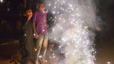 Getty Images This photo taken on November 7, 2018 shows Indian children watching firecrackers during the Diwali Festival celebrations in Ajmer, in western Rajasthan state. - Diwali, the Festival of Lights, marks victory over evil and commemorates the time when Hindu god Lord Rama achieved victory over Ravana and returned to his kingdom Ayodhya. (Photo by Shaukat Ahmed / AFP) (Photo credit should read SHAUKAT AHMED/AFP via Getty Images)