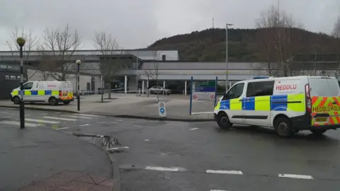 BBC Ysbyty Cwm Rhondda Hospital car park with police vans