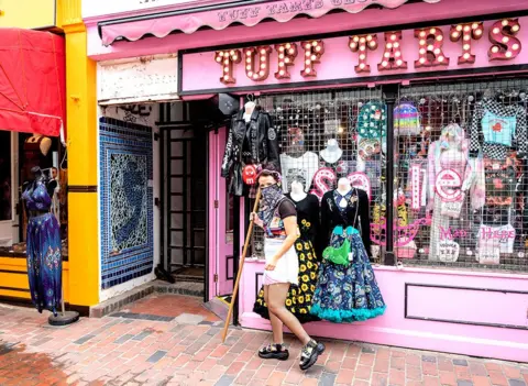 Alamy Live News A worker prepares a fashion shop for customers