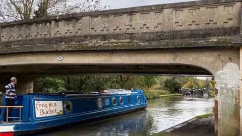 Rob Perryman Rob Perryman steering the narrowboat under a bridge