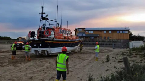 RNLI Wells Mersey lifeboat being taken in at dusk