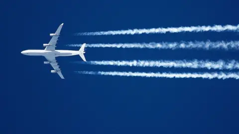 Getty Images A plane flying in a blue sky