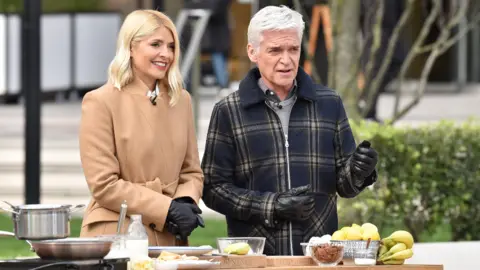 Getty Images Holly Willoughby and Phillip Schofield with Ainsley Harriott attempt a world record for tossing pancakes during the This Morning show. on February 25, 2020 in London, England