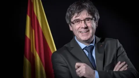 AFP/Getty Images Carles Puigdemont poses in front of a Catalan flag in Brussels, Belgium. Photo: 7 February 2018