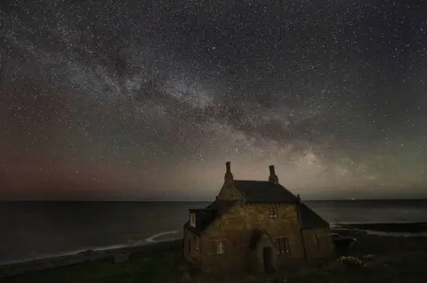 Owen Humphreys / PA Media The Bathing House in Howick under a night sky