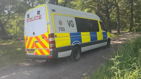 John Fairhall/BBC A police van at Hockley Woods