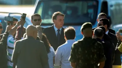 EPA Brazilian President Jair Bolsonaro (C) leaves the Palacio do Alvorada, headquarters of the Presidency, in Brasilia, Brazil, 15 June 2020.