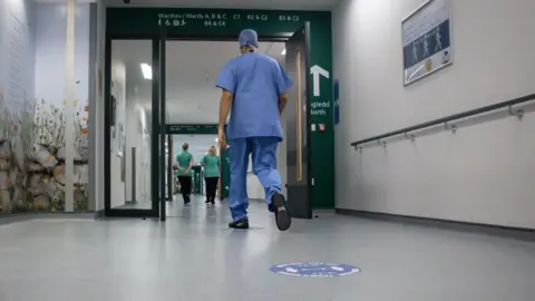 Getty Images Staff walking along a corridor at Grange Hospital, Cwmbran