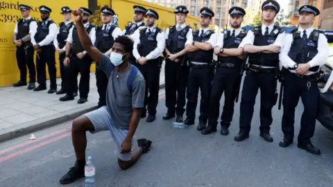 Reuters Police stand behind a protester