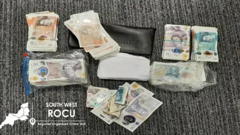 South West ROCU A wallet and a load of folded cash on a table