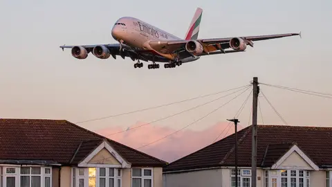 Getty Images Emirates plane flies over houses near Heathrow